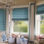 Rullade blå gardiner för ett fönsterfönster till plantskolan