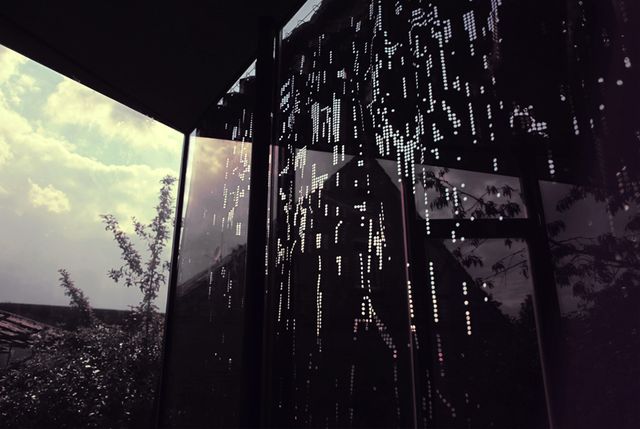 Gatuvy av fönstret med perforerad gardiner nattstad