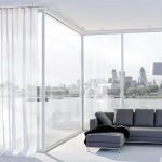 Luftiga vita gardiner för ett panoramafönster
