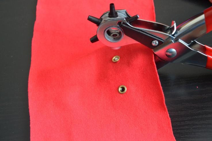Pemasangan Grommet pada kain merah