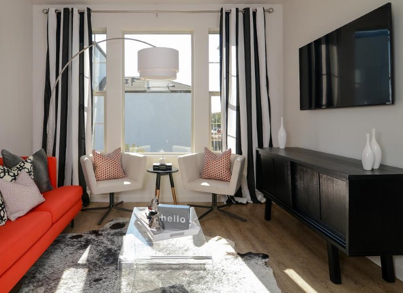 Litet vardagsrum med svart och vit randiga gardiner
