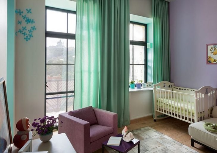 מיטת תינוק בחדר עם וילונות מנטה