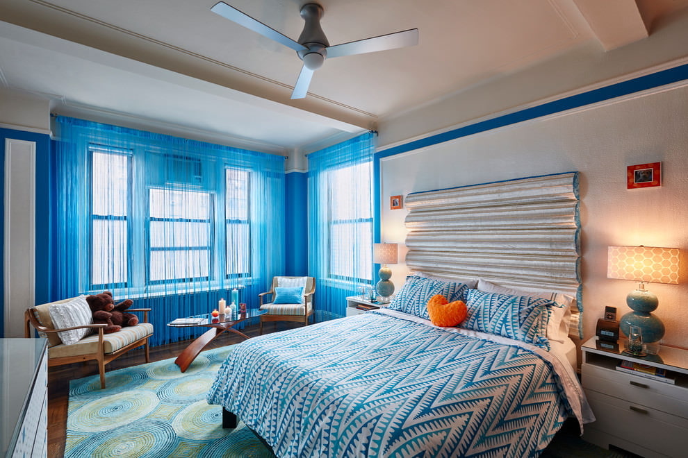 Blåa virkade gardiner i det ljusa sovrummet