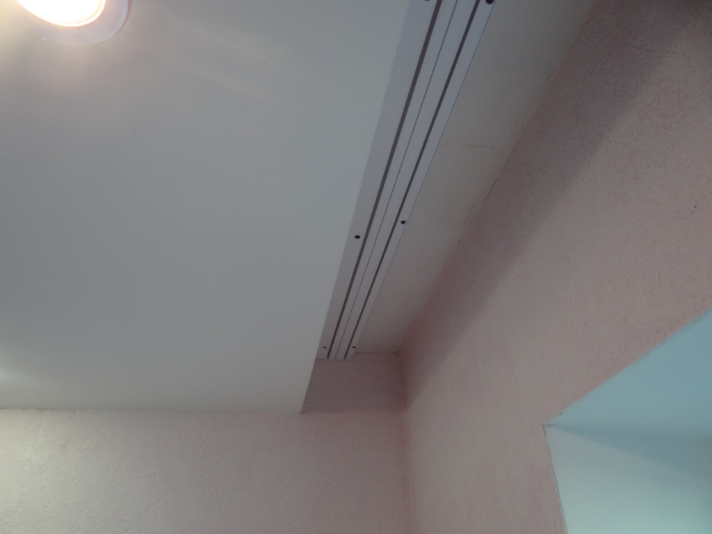 Fissando la grondaia di plastica del binario del soffitto in una nicchia