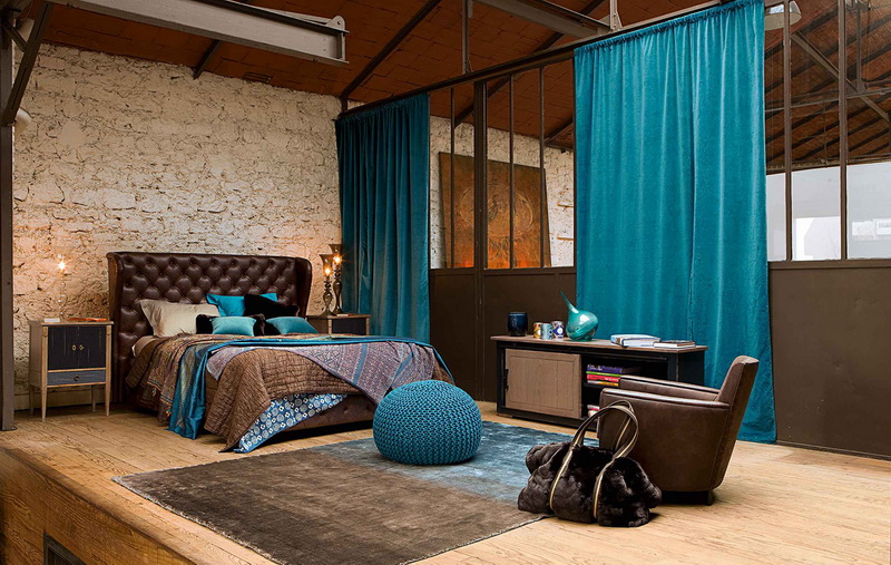 Spacieuse chambre de style loft avec des rideaux turquoise