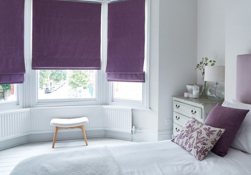 Valkoinen makuuhuone, jossa on roomalaisia ​​violetti sävyjä