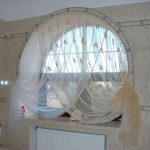 Finestra ad arco con tende in bagno