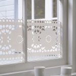 Bílé vzory na okenní sklo