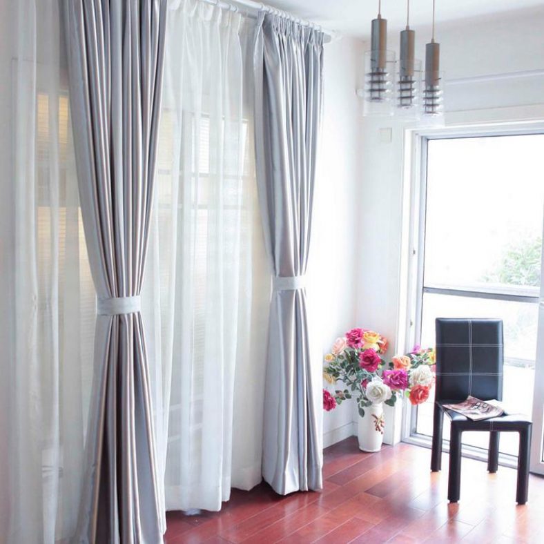 Vackra gardiner med grepp på dörren i vardagsrummet