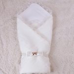 Mooie witte geruite omslag met een elastische strik