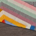 Een kleine deken van 10 loops van kleurrijke strepen
