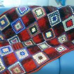 Kostkované na pohovce babiččiných pletených čtverců v kombinaci s vlněnými čtverečky