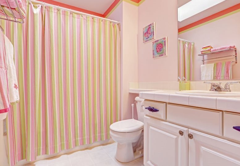 Pruhovaný závěs v koupelně s růžovými stěnami