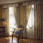 Rak gardiner i vardagsrummet med två fönster med en hård lambrequin.