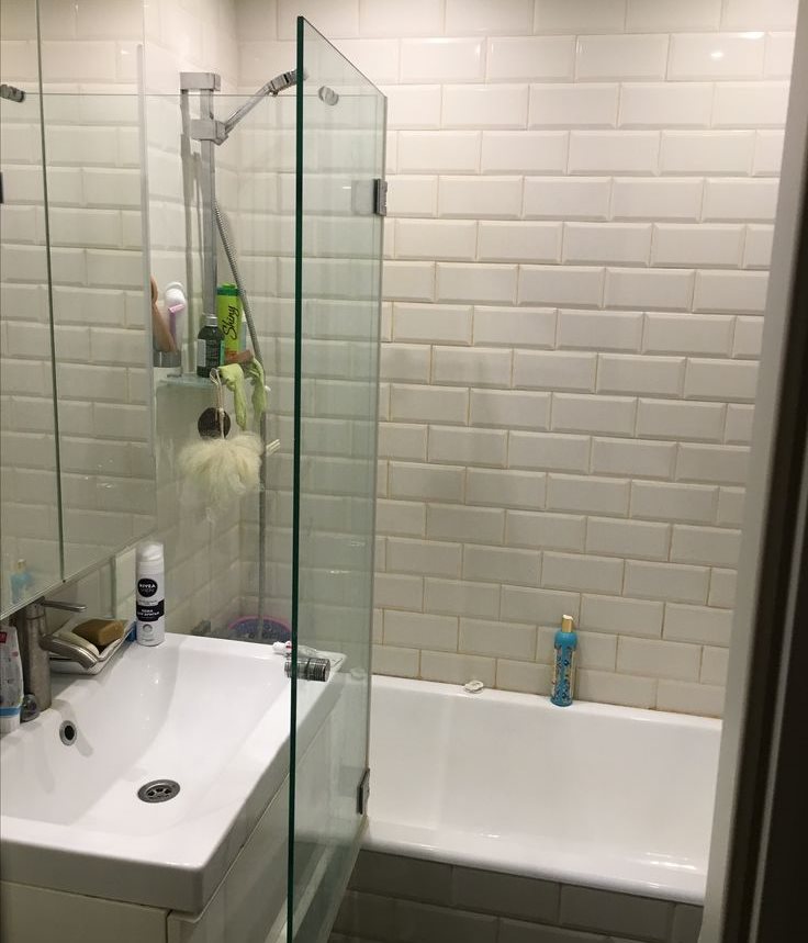 דלת זכוכית תלויה במחיצה בחדר האמבטיה