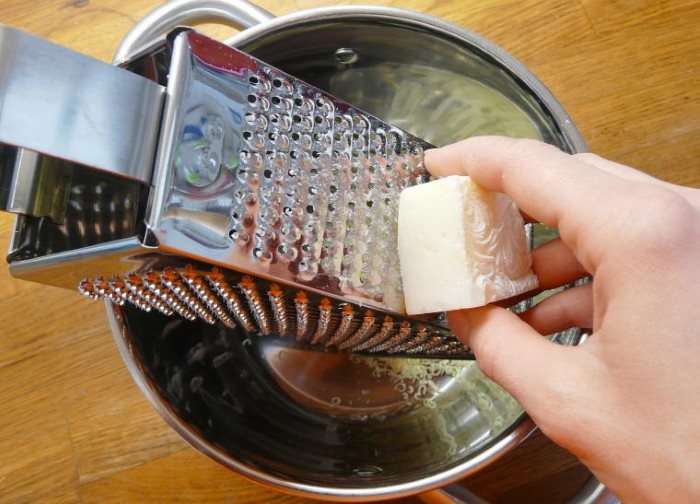 Moudre du savon à lessive sur une râpe en métal