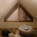 Triangulärt fönster med bruna fönsterluckor för vila rummet