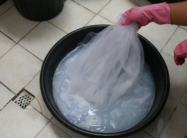 Trempage de tulle mince dans une cuvette en plastique