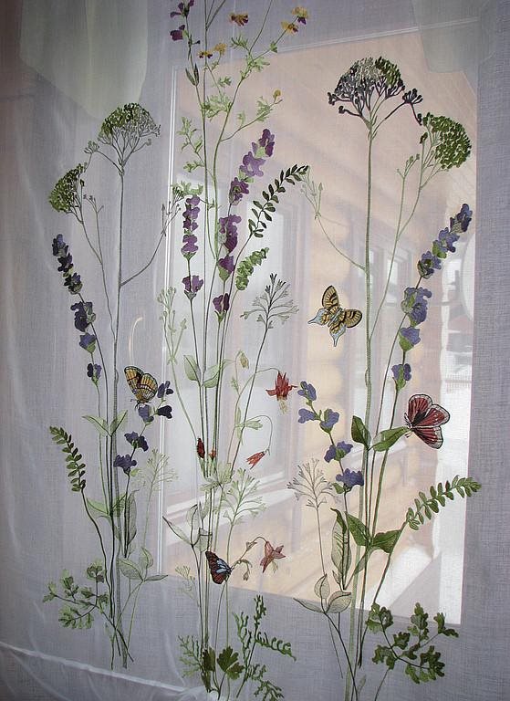 Läpikuultava tylli ja kasvit keittiön ikkunassa