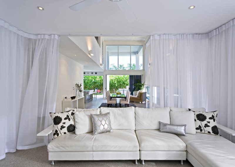 A nappali belső terét fehér függönyök díszítik