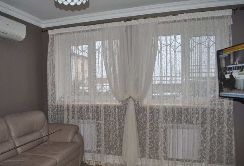 Twee witte tule in het raam van de woonkamer