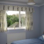 Inredning med korta gardiner i sovrumsfönstret