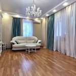 Turkos satin gardiner i vardagsrummet i en stadslägenhet