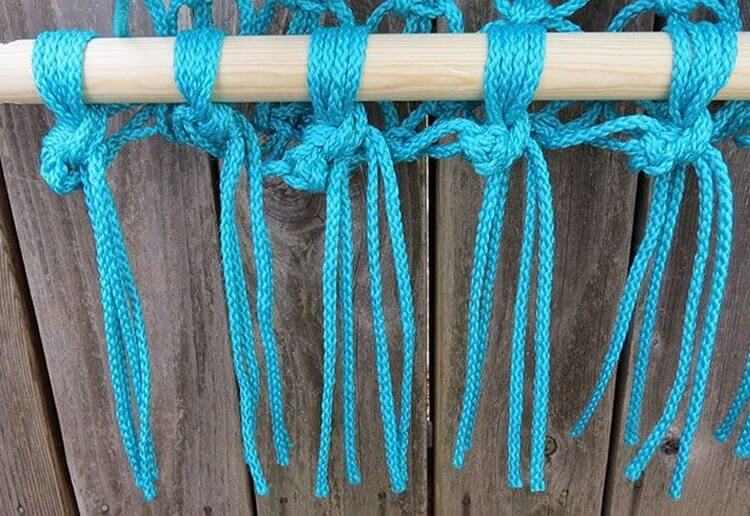 Intrecci nodi di corda turchese su un bastone di legno