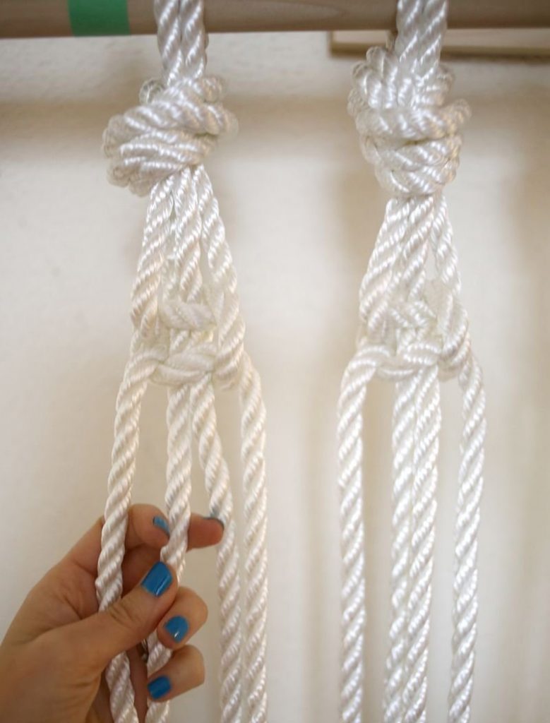 Mengetatkan knot apabila menenun tirai tali sintetik