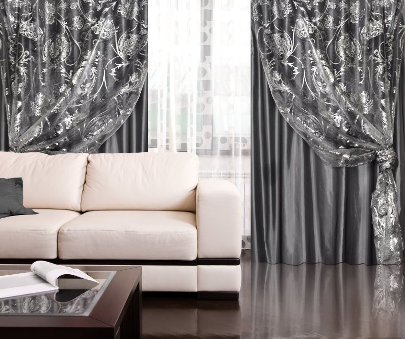 Dubbla grå gardiner i vardagsrummet med ett glansigt golv
