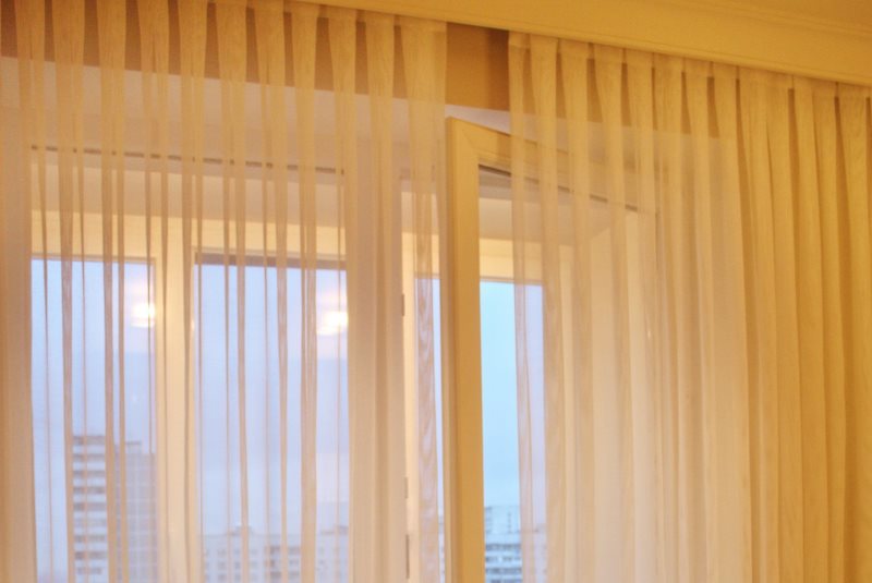 Decorazione della finestra del soggiorno con tulle di organza plissettato